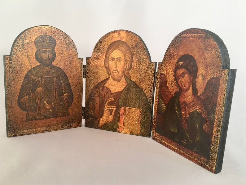 May include: A wooden triptych with three painted panels depicting religious figures. The center panel shows Jesus holding a book, the left panel shows a figure in a crown and robe, and the right panel shows an angel with wings.