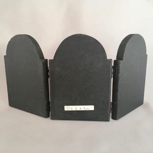 May include: A black wooden triptych with three panels. The center panel has a white label with the text "03 L x L x L" written in blue ink.