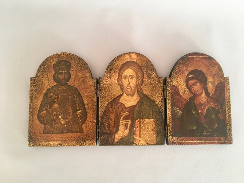 May include: A three-panel wooden icon set with gold accents. The center panel features a painting of Jesus Christ, while the left and right panels depict a king and an angel, respectively.