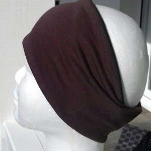 May include: A brown headband made of soft fabric. The headband is wide and has a simple design.