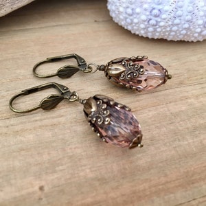 Pode incluir: Um par de brincos com uma forma de l&aacute;grima de cristal rosa e detalhes de filigrana de ouro antigo.
