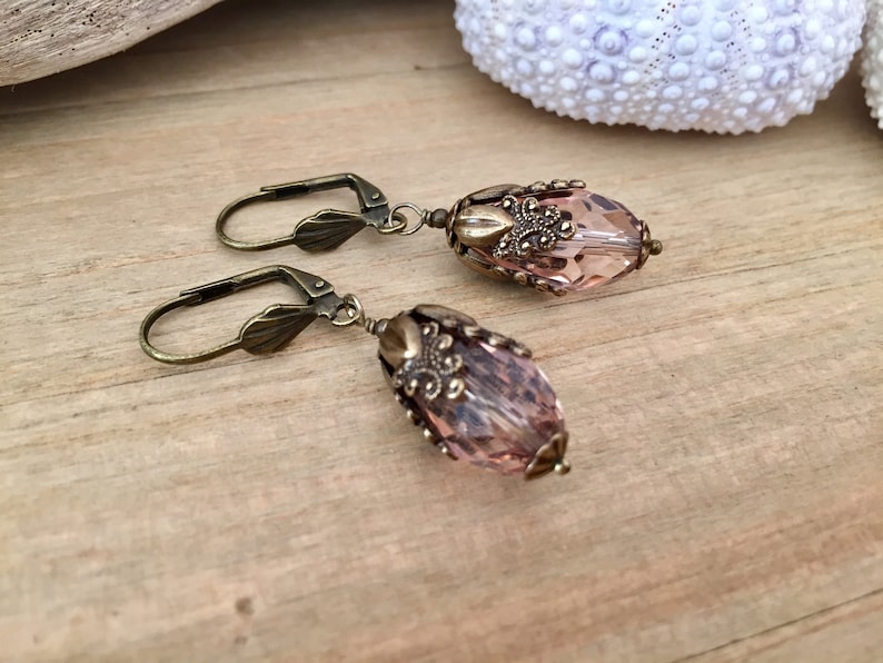 Pode incluir: Um par de brincos com uma forma de l&aacute;grima de cristal rosa e detalhes de filigrana de ouro antigo.