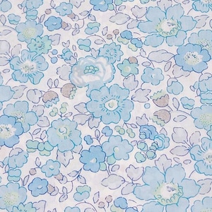Puede incluir: Una tela blanca con un patrón floral azul. Las flores son pequeñas y delicadas, de color azul claro. La tela tiene un brillo sutil.