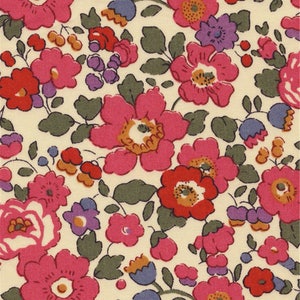 Puede incluir: Patrón floral con fondo crema. El diseño presenta flores rosas, rojas y moradas, complementadas con hojas y tallos verdes. Las flores tienen centros amarillos.