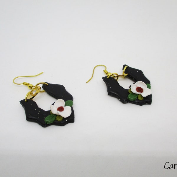 Boucles d'oreilles chauves-souris en pâte polymère noir et or avec une fleur blanche