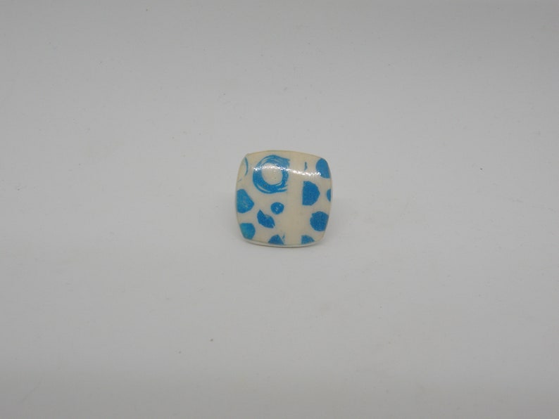Square ring in white and round blue polymer paste