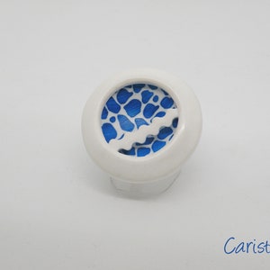 Könnte beinhalten: Weißer Ring mit einem blauen und weißen Muster. Das Muster besteht aus einer Reihe blauer Punkte auf weißem Hintergrund. Der Ring hat einen weißen Band um den Rand.