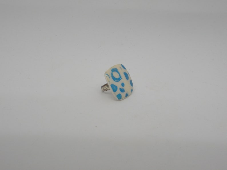 Square ring in white and round blue polymer paste