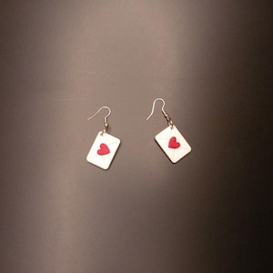 May include: A white ceramic mug with a black handle and the text "But First, Coffee" in a black, handwritten-style font. The mug is on a white surface.