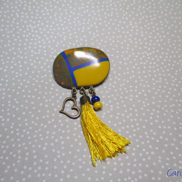 Oval yellow and blue polymer clay brooch with yellow and blue tassel, yellow and blue beads and bronze heart primer