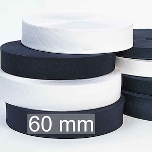 Pode incluir: Uma pilha de faixas elásticas em branco e azul marinho. As faixas têm 60 mm de largura. A imagem mostra vários rolos de elástico, com os rolos superiores em branco e azul marinho.