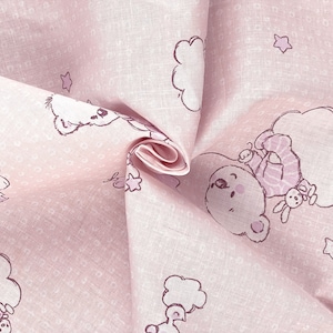 Pode incluir: Tecido rosa claro com um padrão repetido de ursos de desenho animado, nuvens e estrelas. Os ursos e os contornos das nuvens são de cor lilás claro. O tecido está dobrado, mostrando a textura e os detalhes do design.