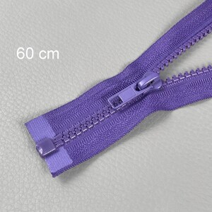 May include: A close-up of a purple zip, 60 cm long, against a light grey background. The zip is open, showing the teeth and the slider. The zip is a vibrant shade of purple.