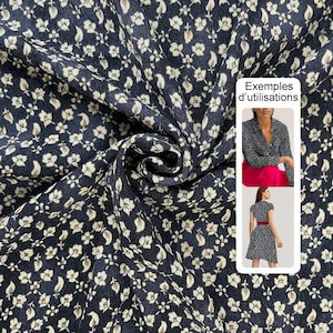 Pode incluir: Tecido azul marinho escuro com um padrão repetido de pequenas flores e folhas brancas. O tecido é reunido em dobras macias, mostrando a impressão detalhada. A imagem inclui exemplos de como o tecido pode ser usado, com o texto "Exemples d'utilisations".