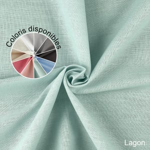 Puede incluir: Primer plano de una tela verde claro con un tejido texturizado. Una rueda de colores muestra varias opciones de color de tela. La palabra "Lagon" es visible en la esquina inferior derecha. La tela está doblada, creando una forma espiral.