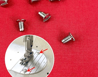 May include: Close-up of several silver machine screws scattered on a red background. A sewing machine's needle plate is shown with two screws in place. The screws have a slotted head.