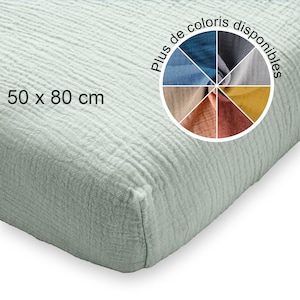 Pode incluir: Um tecido verde claro e texturizado de 50 x 80 cm. Uma roda de cores mostra várias opções de cores. O tecido parece ser um material macio e enrugado, possivelmente algodão ou linho.