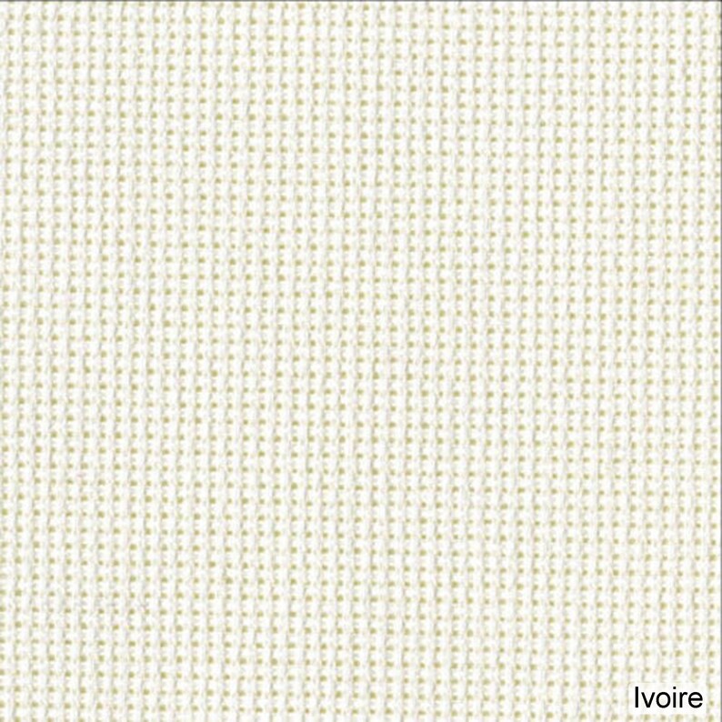 May include: Close-up of a textured ivory fabric. The weave is tight, creating a grid-like pattern. The color is a warm off-white, with a subtle variation in tone across the surface. The word "Ivoire" is printed in the bottom right corner.