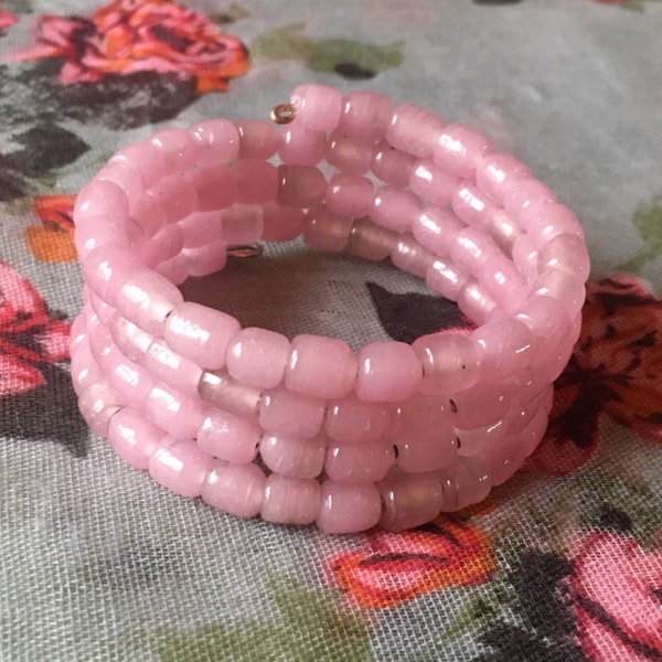 Bracelet en perles rose brillant, artisanales, multirangs / quatre rangs sur fil de métal à mémoire de forme de 5cm de diam.