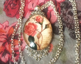 Old red rose pendant necklace, flower engraved medallion, sepia background, silver chain, vintage, retro romantic, boho, bohemian