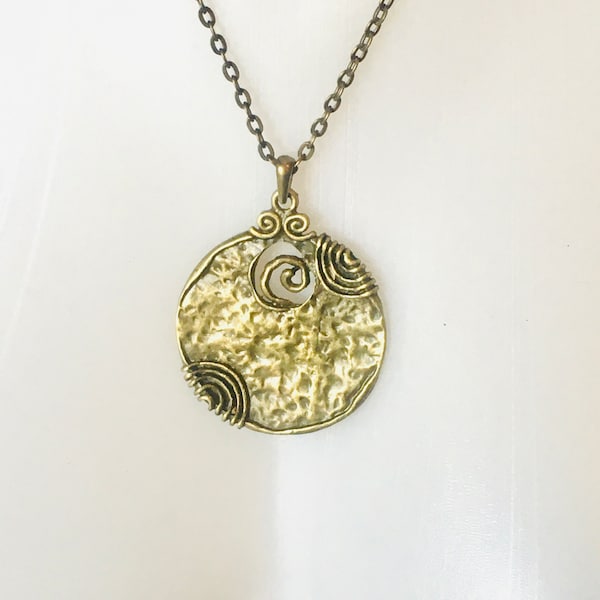 Pendentif tribal rond bronze doré antique motif cercles et spirales, martelé, sur chaîne bronze. Tout en courbes. Simple et optimiste