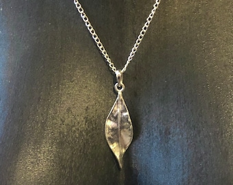 Platinum silver leaf pendant necklace, elongated and thin, twisted like laurel, delicate, realistic, natural, minimalist