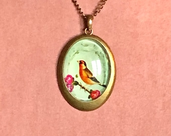 Collier pendentif vintage oiseau tons orange sur branche fleurie et fond vert d’eau décoré sur médaillon ovale bronze, bucolique, romantique