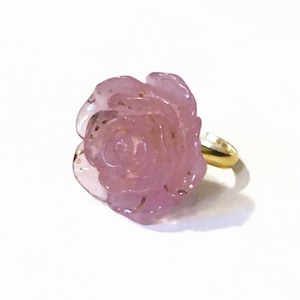 May include: A pink rose-shaped ring with a gold band.