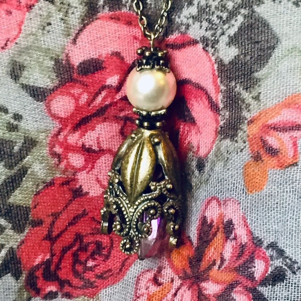 Collier pendentif à clochette florale baroque bronze ornementée, perle oblongue transparente irisée à l’intérieur et perle nacrée ivoire