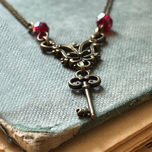 Collier clé, clé Alice avec cristaux rouges et filigrane bronze avec citation d'Alice « Nous sommes tous fous ici », bijoux bohèmes, coffret cadeau