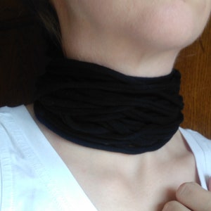 Peut inclure: Un collier ras de cou en tissu noir porté autour du cou d'une personne.