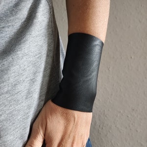 マットブラックフェイクレザーリストカフ、ワイドリストカフブレスレット、ゴシックタトゥーカバーアップ、ブラックブレイサー、大人用パンクロックリストバンド、ティーンズリスト