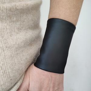 マットブラックフェイクレザーリストカフ、ワイドリストカフブレスレット、ゴシックタトゥーカバーアップ、ブラックブレイサー、大人用パンクロックリストバンドティーンズリスト