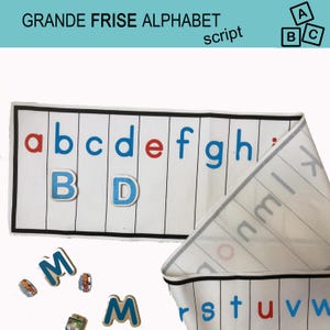 May include: A white alphabet mat with black lines and blue, red, and black letters. The mat is rolled up and the letters are scattered around it. The mat says "GRANDE FRISE ALPHABET script" at the top.