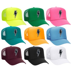 May include: Ten trucker hats in different colors with a black lightning bolt graphic on the front. The hats are all mesh backed.