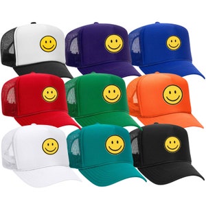 Peut inclure: Dix casquettes de camionneur avec un dos en maille de différentes couleurs, chacune arborant un smiley jaune sur le devant.
