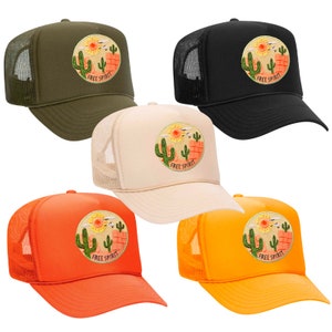 May include: Five trucker hats in different colours with a cactus and sun graphic and the text "Free Spirit". The hats are green, black, beige, orange and yellow.