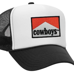 May include: A white and black trucker hat with a red and white patch that says "cowboys*" in black lettering.