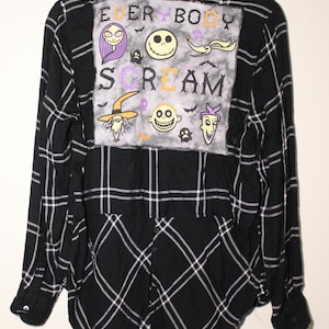 Könnte beinhalten: Schwarzes und weißes kariertes Flanellhemd mit einem großen, bunten Patch auf der Rückseite. Der Patch zeigt Figuren aus dem Film "Nightmare Before Christmas" und den Text "Everybody Scream".