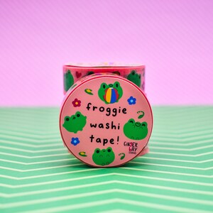 May include: Pink and green frog-themed washi tape with the text "froggy washi tape!" and the brand name "Ginger Bay Studios".