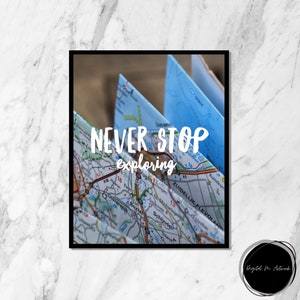 Può includere: Un primo piano di una mappa piegata con il testo "NEVER STOP exploring" scritto in bianco sopra la mappa. La mappa è blu e bianca e mostra una varietà di strade e città.