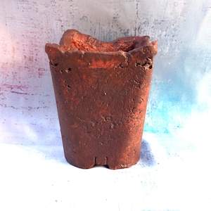Peut inclure: Un pot de fleurs rectangulaire en céramique de couleur terre cuite avec une texture de surface rugueuse, poreuse et inégale. Le récipient présente un bord épais moulé à la main avec un contour organique irrégulier et un intérieur creux.