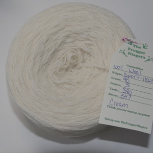 May include: A skein of cream-colored wool yarn, labeled as 100% wool, Sport-18WPI, weighing 90 grams (3 ounces), with 380 yards (347 meters).