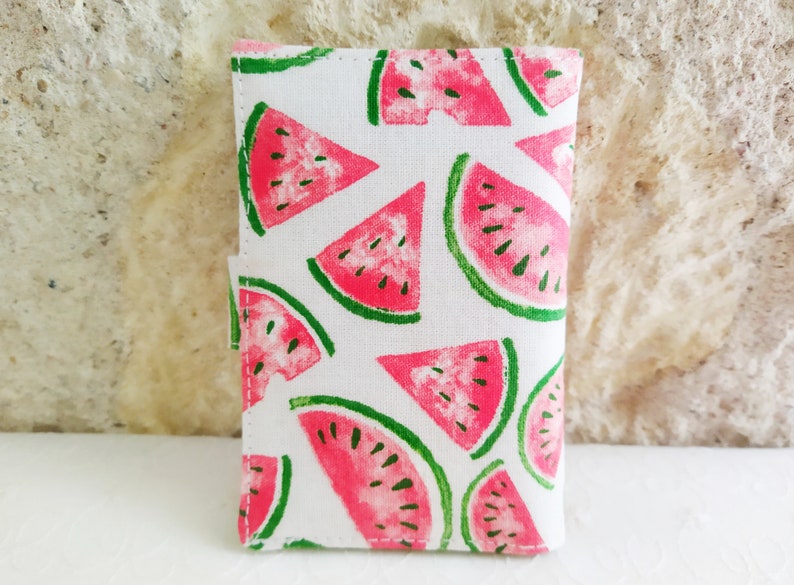 May include: A white fabric pouch with a watermelon print. The pouch has a zipper closure and is perfect for carrying small items.