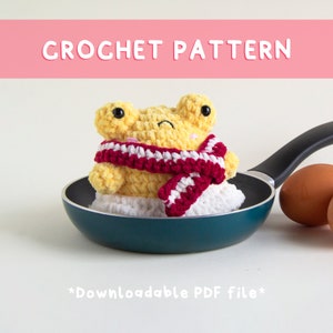 May include: Crochet pattern for a yellow amigurumi frog wearing a red and white scarf, sitting in a frying pan with eggs. *Downloadable PDF file*