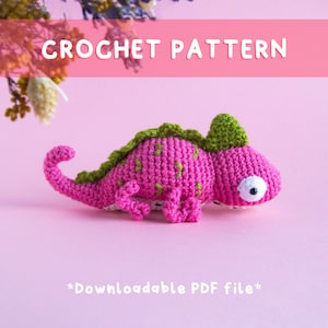 May include: Crochet pattern for a pink chameleon with green accents. The pattern is available as a downloadable PDF file.