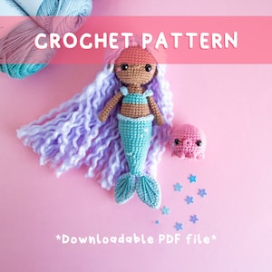 May include: Crochet pattern for a mermaid doll with long purple hair, a turquoise tail, and a pink octopus. The pattern is downloadable as a PDF file. The image also shows pink yarn and blue yarn.