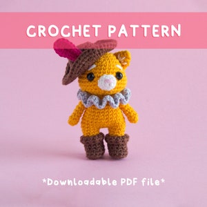 Puede incluir: Patrón de crochet para un lindo gato amigurumi amarillo que lleva un sombrero marrón con una pluma rosa, un cuello de volantes gris y botas marrones. El patrón es descargable como archivo PDF. *Archivo PDF descargable*