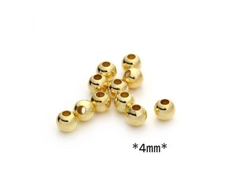 Op de afbeelding: Een verzameling glanzende, goudkleurige kralen, elk ongeveer 4 mm in diameter, op een witte achtergrond. De kralen hebben een glad, reflecterend oppervlak en een gat in het midden. De tekst "*4mm*" is zichtbaar.