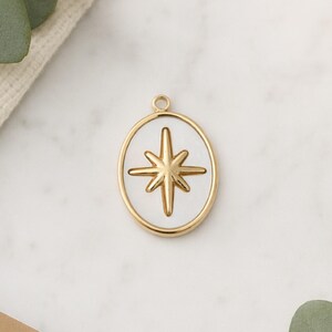 Hanger van natuurlijk parelmoer en 14-karaats verguld roestvrij staal. Ovale parelmoeren medaille met de Noordster.